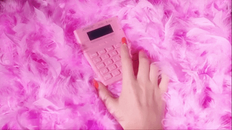 a person with pink manicured nails taps on a pink calculator that rests atop a pile of pink feathers