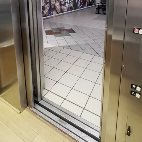 A person tries to crawl out of an elevator.