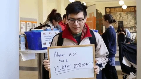 A student holding up a whiteboard that says