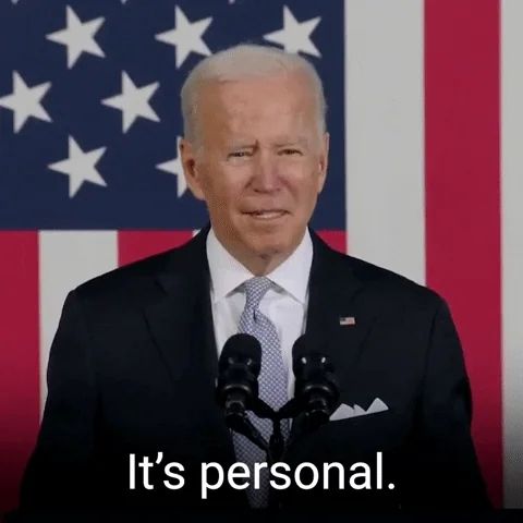Joe Biden in front of an American flag and microphone. He says, 