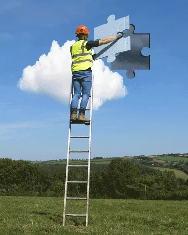 A construction worker on a ladder holds a puzzle piece that they connect to the sky.