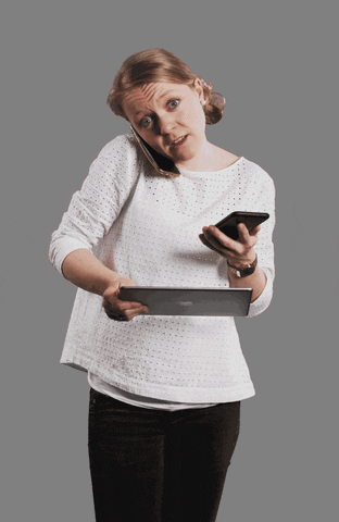 Woman answering a phone while holding a tablet while four other calls come up for her