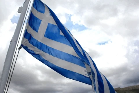 A Greek flag waving in the wind.