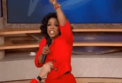 Oprah pointing at people in her audience.