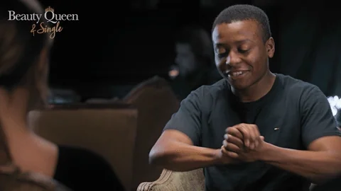 A man cracks his knuckles and smiles.