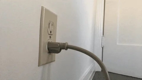 A cartoon hand coming out of power outlet and pulling plug out of bottom outlet
