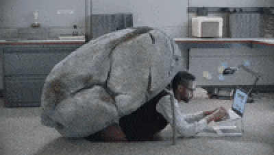 GIF of office worker hiding under a rock