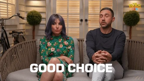 A woman and a man sitting on a bench nod while saying, "Good choice."