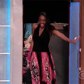 An excited woman hops through a doorway.