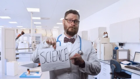 دکتر در حال نشان دادن کاغذی با علامت 'علم' روی آن.