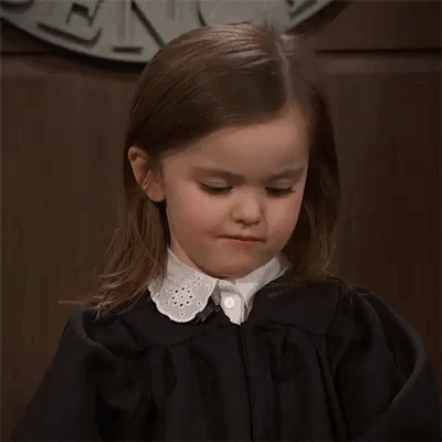 Child in judge's robe giving the side-eye, a negative expression.