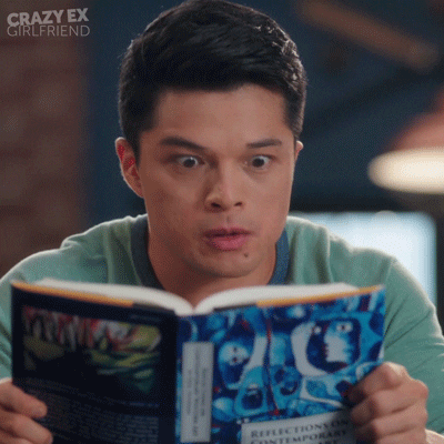 Young student squinting eyes trying to stay awake while reading textbook.
