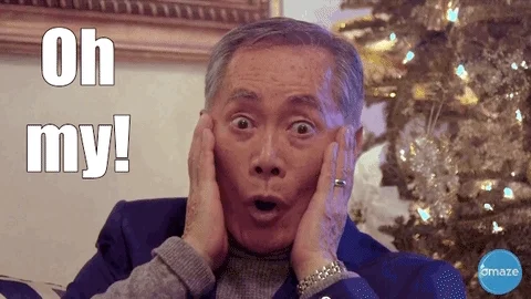 An elderly Asian man has both hands on his head and says 
