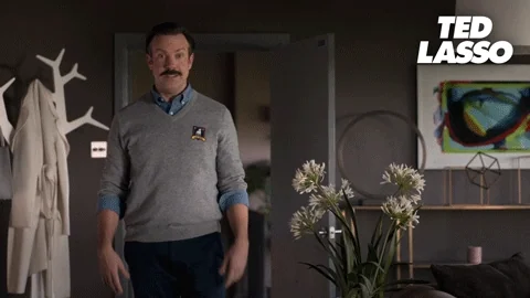 Jason Sudeikis as Ted Lasso wiggling his fingers by his ears, saying 