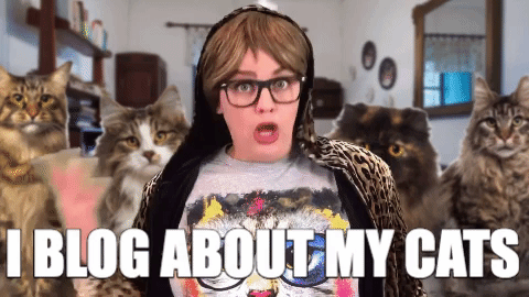A woman surrounded by cats saying, 'I blog about my cats!'