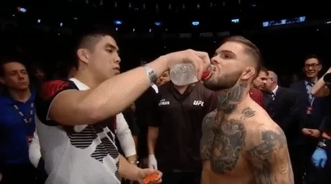 GIF of man giving water to a wrestler
