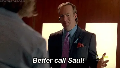 Saul Goodman wearing a suit, pointing his right index finger, and saying, 'Better call Saul!'