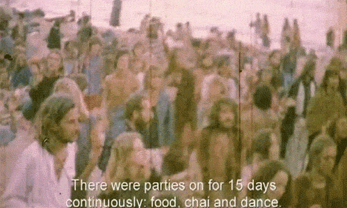 Old footage of hippies dancing. A subtitle reads, 