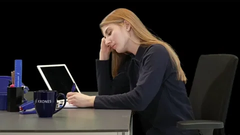 A woman falling asleep at her computer.