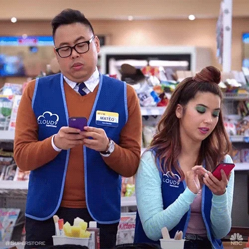 Mateo and Cheyenne from Superstore texting on their phones.