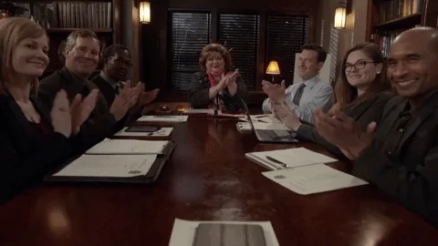People clapping around a conference table on the show Good Witch.