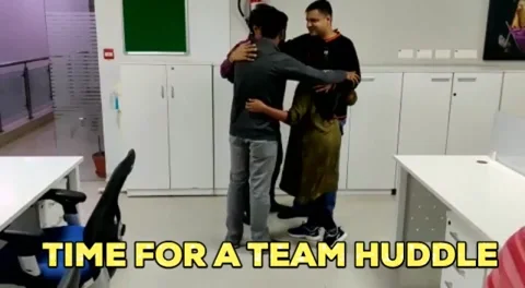 Four teachers hug, then give each other high fives. The text reads: 