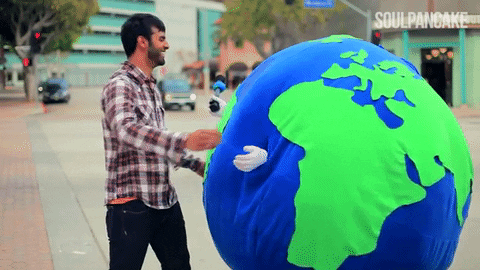 A person is hugging someone dressed in an Earth (globe) costume