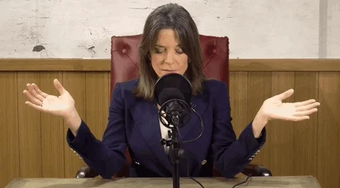 Marianne Williamson meditating in front of a microphone.