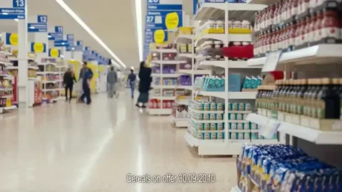 Person flying across a supermarket aisle, holding the shopping cart behind.