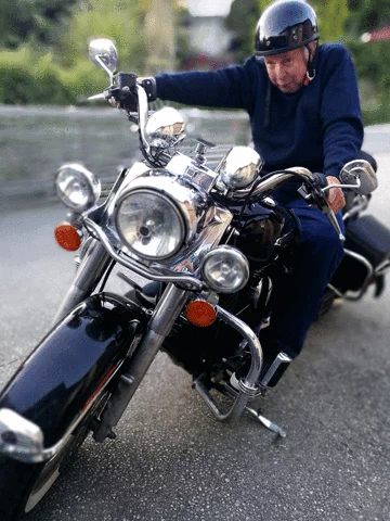 Image showing a funny older man shifting gears while seated on a standing bike and making funny faces
