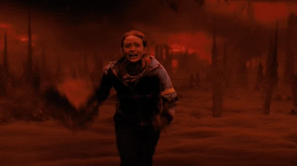 GIF from the show Stranger Things showing a character running away from apocalyptic destruction  behind her.
