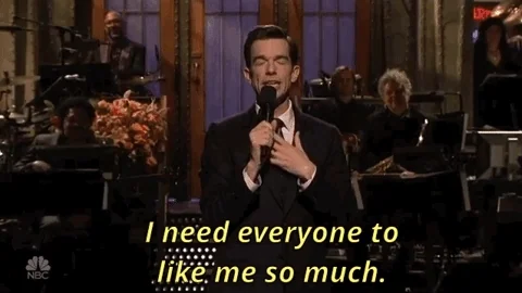 John Mulaney talking into a mic saying 