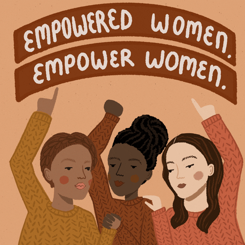 Three women under a sign that reads, 'Empowered women, empower women.'