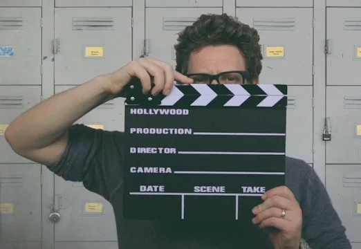 A man holding a clapperboard to mark 