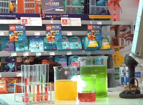 A woman in a lab mixing chemicals in beakers.