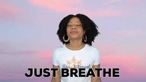 A person joins their palms together and takes a deep breaths, with the words 