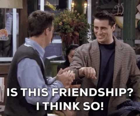 Friends characters Joey and Chandler face each other smiling  while overlaid text reads 