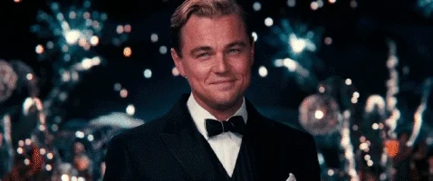 The Great Gatsby raisin a champagne glass at a party
