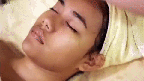 Facial GIF: Skin care technician is applying a skin care product to their client's face. 
