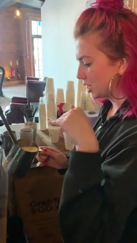 A barista confidently foams a latte.