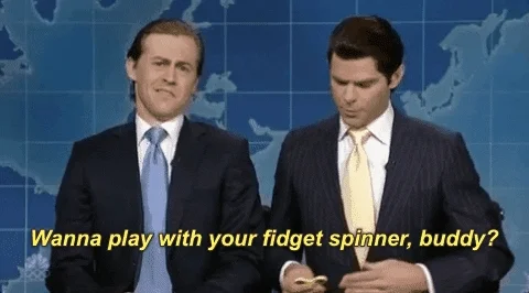 Two men in suits saying 'Wanna play with your fidget spinner, buddy?'