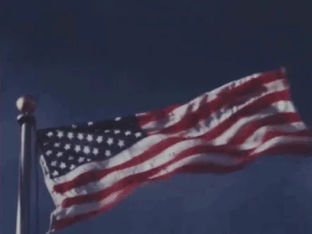 Newsreel footage of the US flag waving in the wind.
