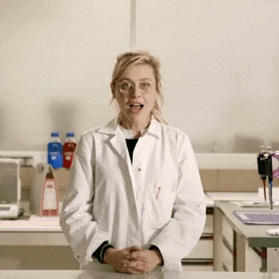 A woman in lab coat. She is excited to be in scientific laboratory