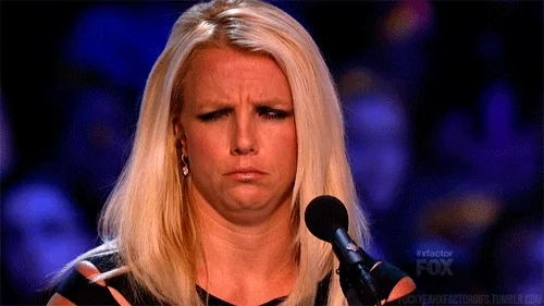 Britney Spears in front of a microphone, looking confused.