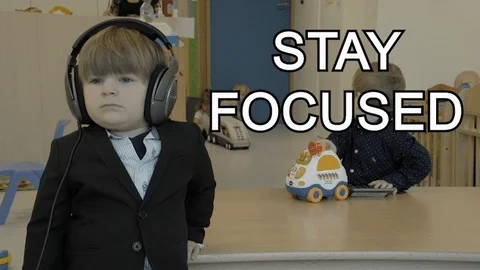 A child in a suit wears headphones in a busy daycare. The text reads, 