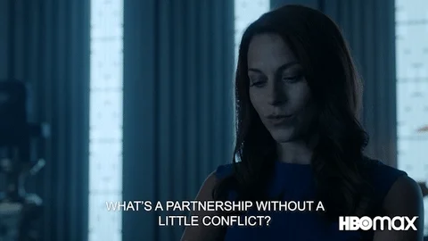 A person saying 'What's a partnership without a little conflict?' and smiling.
