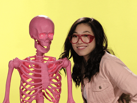 Girl smiling and looking at a pink skeleton