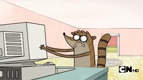 A GIF of cartoon raccoon angrily shaking a desktop computer