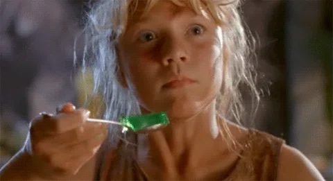 clip from Jurassic Park movie, girl with a terrified expression and hand shaking as she holds a spoon of jello