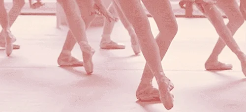 The feet of dancers moving in a dance studio.